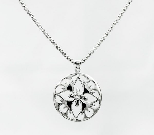 round silver pendant with cut-out pattern